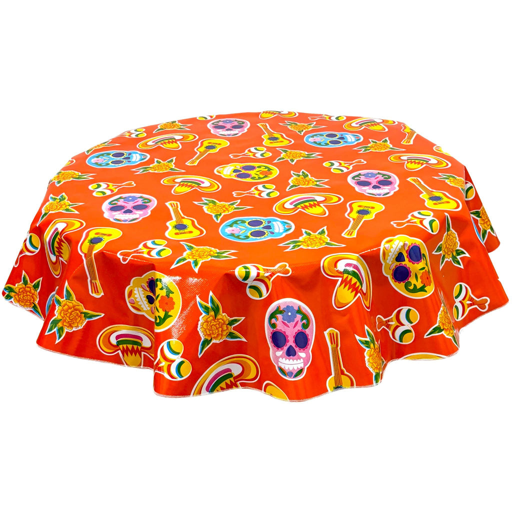 freckled sage round skulls on orange oilcloth tablecloth