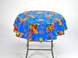 freckled sage fruit basket on blue round tablecloth